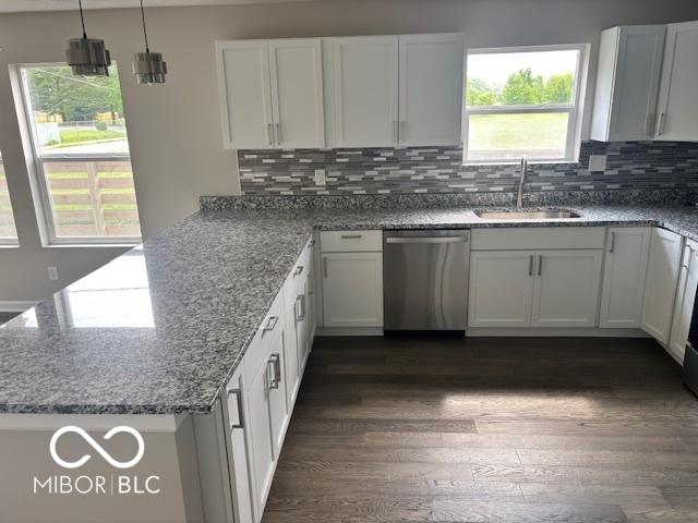1305 W 23rd St, Indianapolis, IN 46208 - kitchen with dishwasher, a sink, a peninsula, dark wood-type flooring, and decorative backsplash