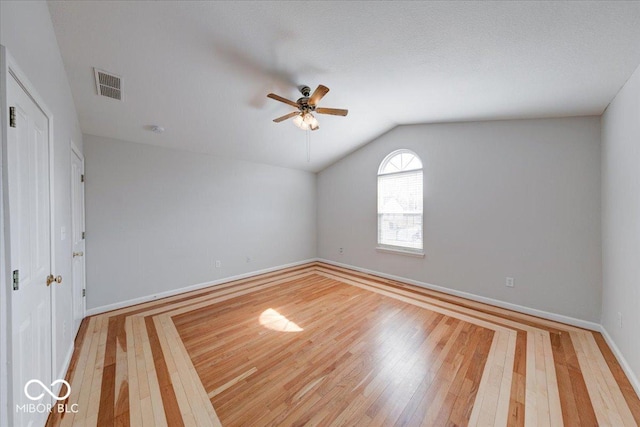 unfurnished room with baseboards, visible vents, lofted ceiling, ceiling fan, and light wood-type flooring