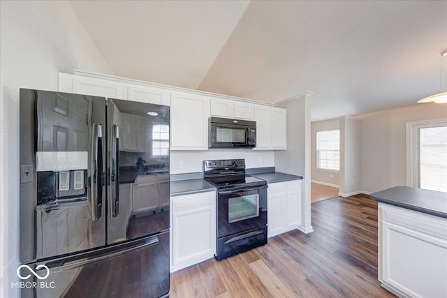 kitchen with black appliances, white cabinets, dark countertops, and light wood-style floors