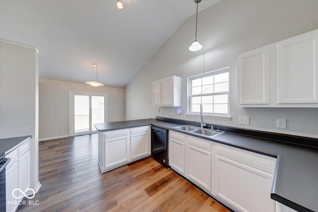 kitchen with dark countertops, dishwasher, white cabinetry, and a sink