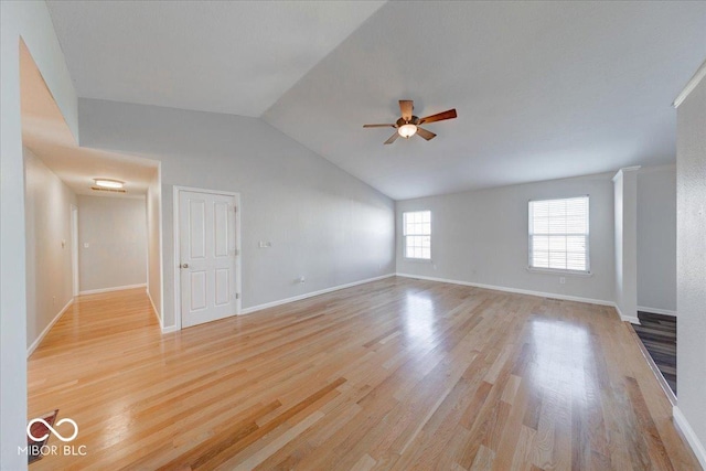 unfurnished living room with vaulted ceiling, light wood-style flooring, baseboards, and ceiling fan