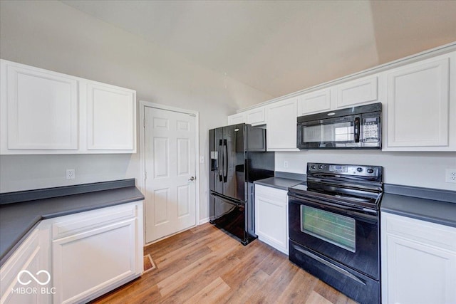 kitchen with dark countertops, white cabinets, and black appliances