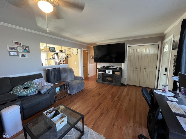 living room featuring crown molding, ceiling fan, hardwood / wood-style flooring, and a textured ceiling