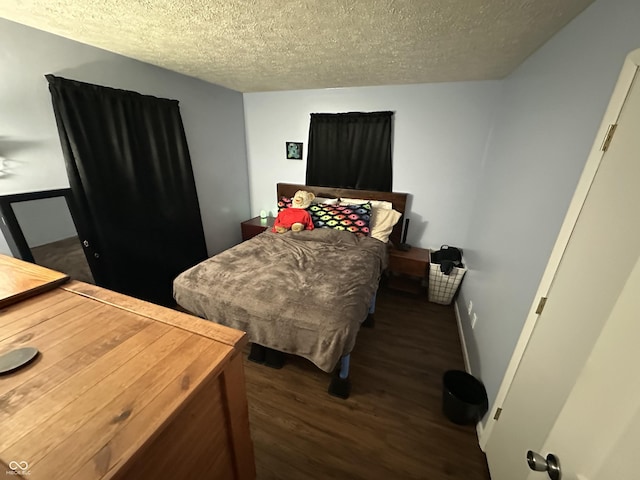 bedroom with a textured ceiling and wood finished floors