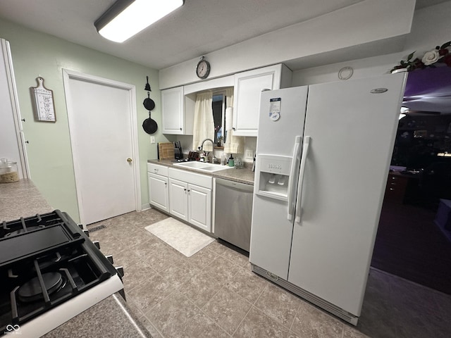 kitchen with white cabinets, dishwasher, gas range, white fridge with ice dispenser, and a sink