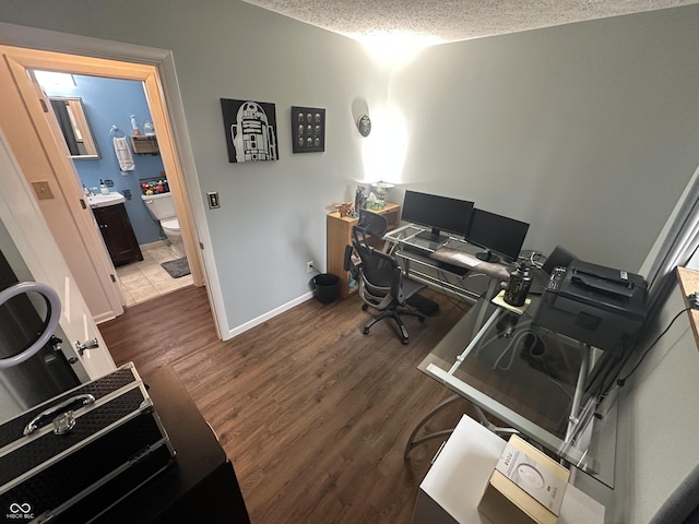 home office with a textured ceiling, wood finished floors, and baseboards