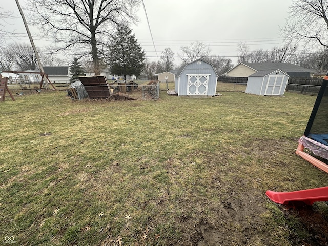 view of yard with an outbuilding, a storage unit, and a fenced backyard