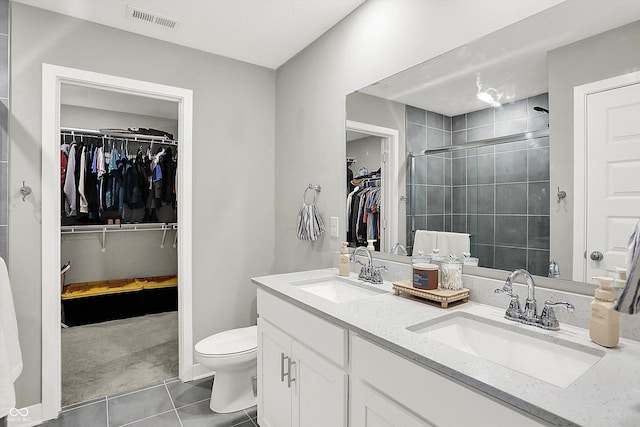 bathroom featuring vanity, tile patterned flooring, a shower with shower door, and toilet