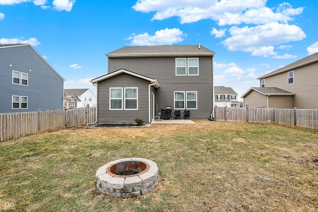 rear view of property with a fire pit, a lawn, and a patio