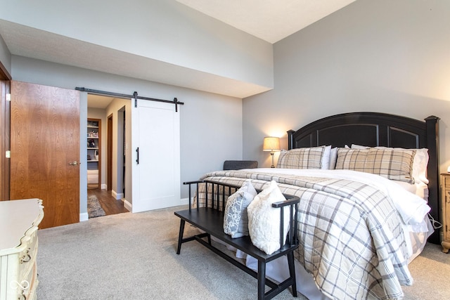 bedroom featuring carpet flooring and a barn door