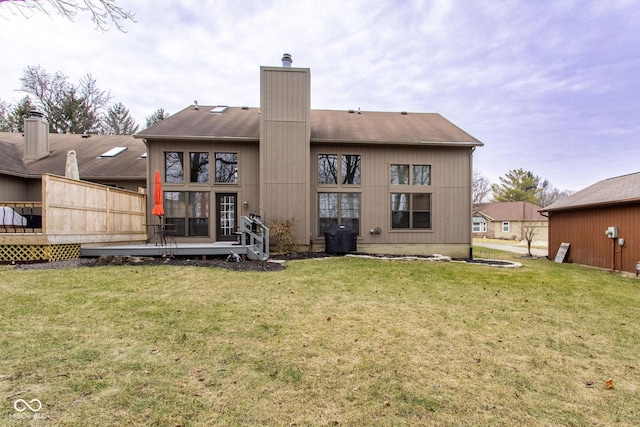 rear view of property with a yard and a deck