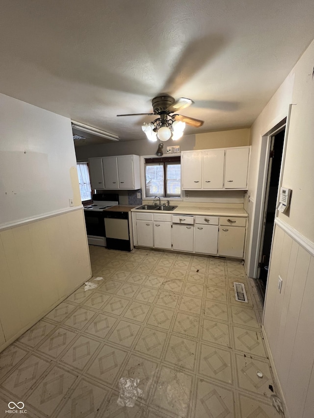 kitchen with white cabinetry, electric range, sink, and a wealth of natural light