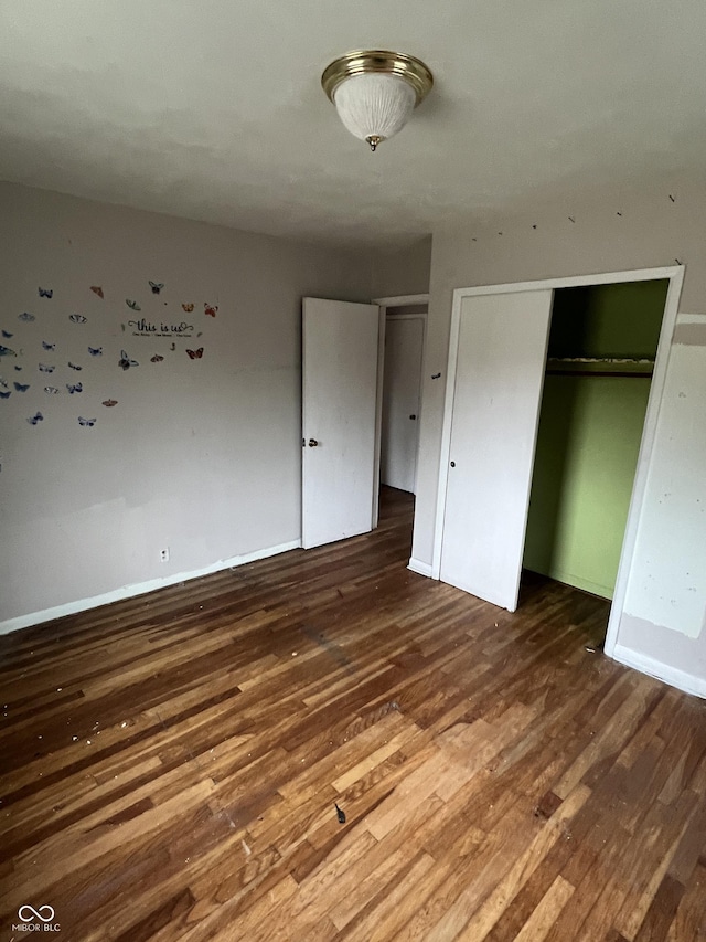 unfurnished bedroom featuring dark hardwood / wood-style floors and a closet