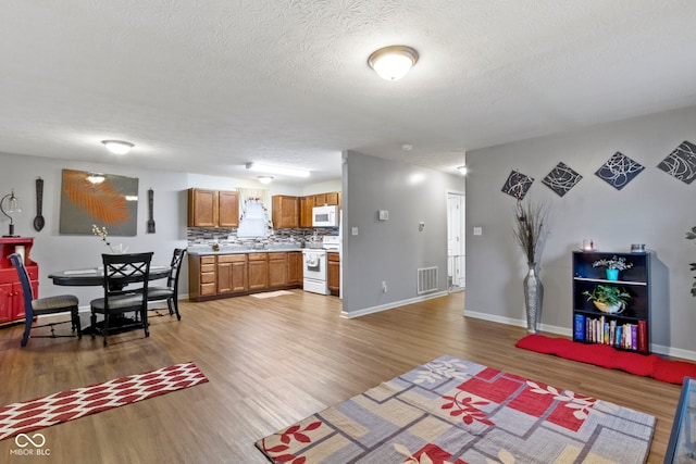 living room featuring wood-type flooring and a textured ceiling