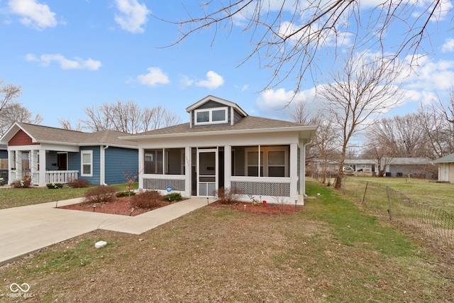 view of front of property with a front yard, a sunroom, and covered porch