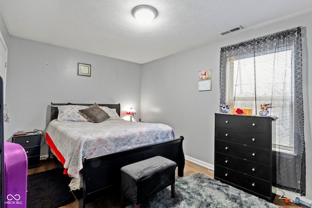 bedroom with a textured ceiling and light wood-type flooring