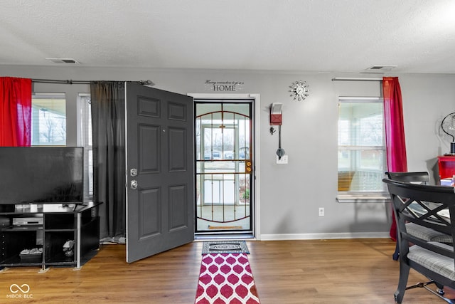 entryway featuring hardwood / wood-style flooring and a textured ceiling