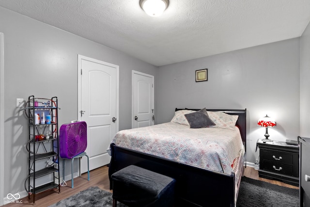 bedroom with dark wood-type flooring and a textured ceiling