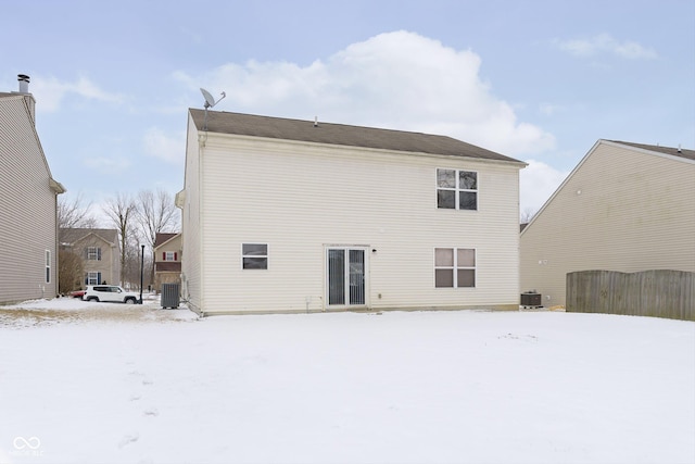 snow covered back of property featuring central air condition unit