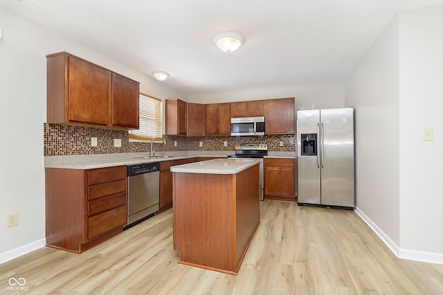 kitchen with tasteful backsplash, a kitchen island, stainless steel appliances, and light countertops