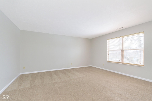 spare room with baseboards, visible vents, and light colored carpet