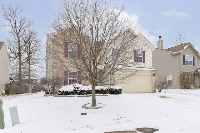 traditional-style home featuring cooling unit, brick siding, and an attached garage