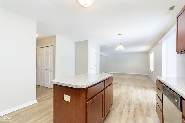 kitchen with decorative light fixtures, light countertops, open floor plan, a kitchen island, and dishwasher