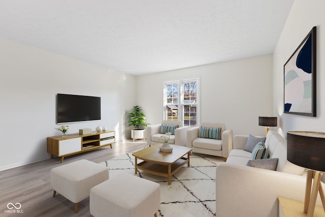 living area featuring light wood-style floors, baseboards, and a textured ceiling