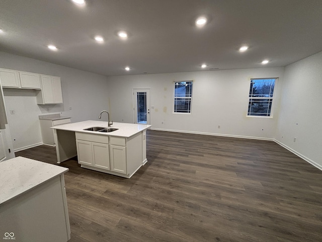 kitchen featuring a kitchen island with sink, sink, white cabinetry, and dark hardwood / wood-style flooring