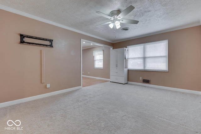 unfurnished bedroom with ornamental molding, light colored carpet, and a textured ceiling