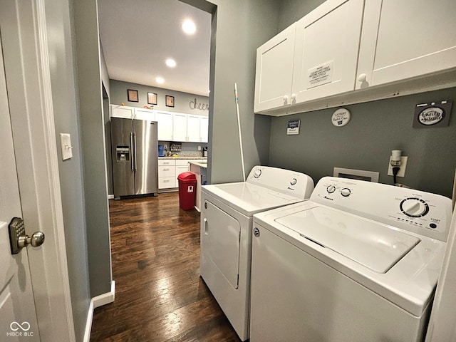 washroom featuring dark hardwood / wood-style flooring, washer and clothes dryer, and cabinets