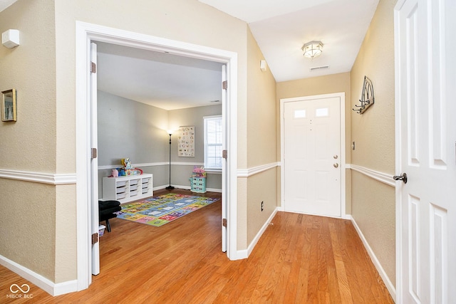 entrance foyer with visible vents, baseboards, and wood finished floors