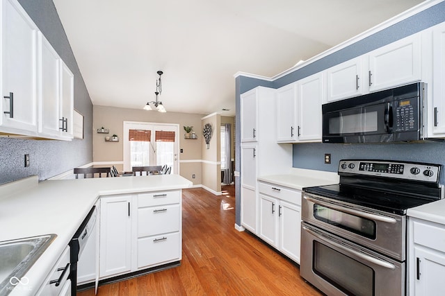 kitchen with black microwave, light countertops, pendant lighting, and double oven range