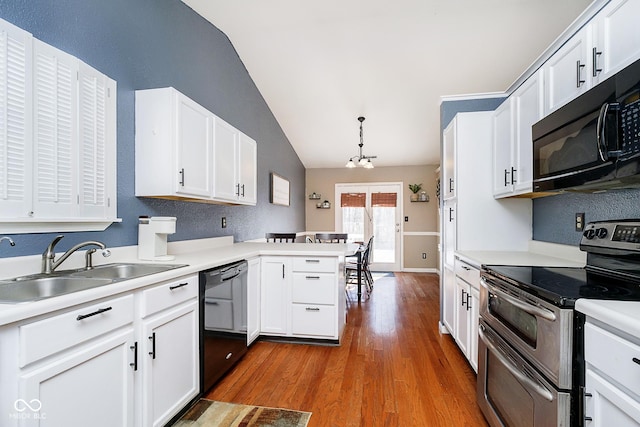 kitchen with white cabinets, a peninsula, light countertops, black appliances, and pendant lighting