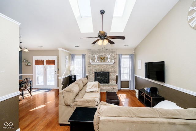 living room featuring a fireplace, a wealth of natural light, and wood finished floors