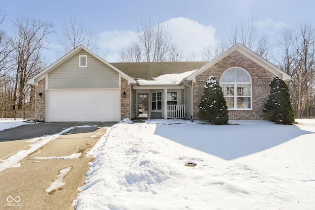 ranch-style house with a garage, brick siding, a porch, and aphalt driveway