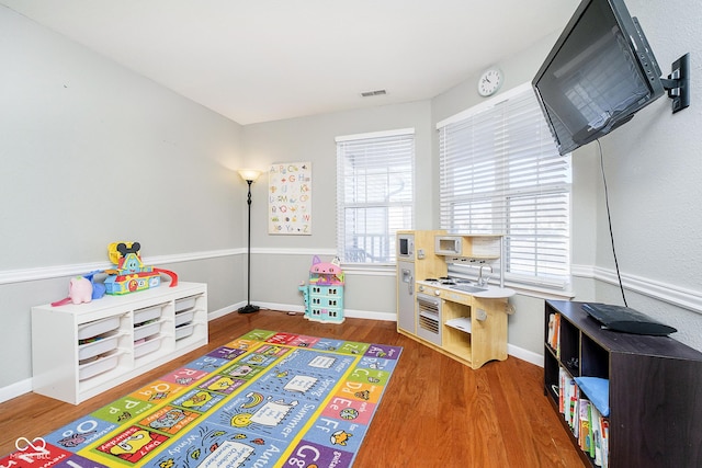 rec room featuring visible vents, baseboards, and wood finished floors