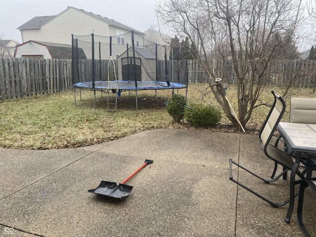 view of patio / terrace with a trampoline and a storage shed