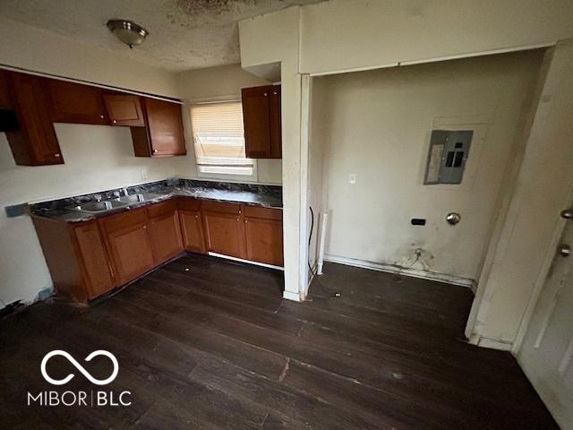 kitchen featuring dark wood-type flooring, electric panel, and a textured ceiling