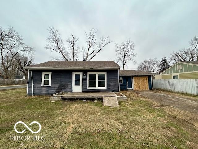 rear view of house featuring a yard