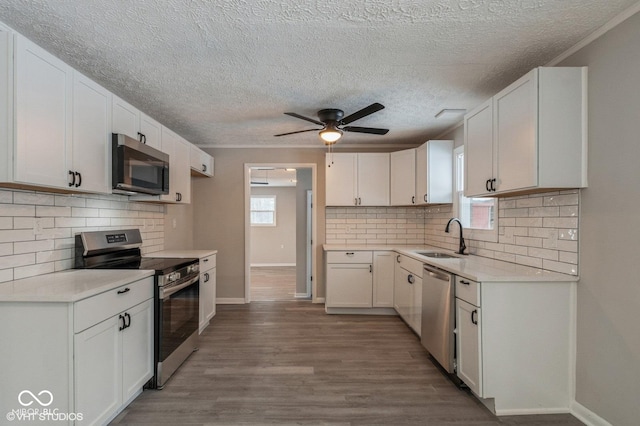 kitchen featuring stainless steel appliances, white cabinetry, sink, and hardwood / wood-style floors