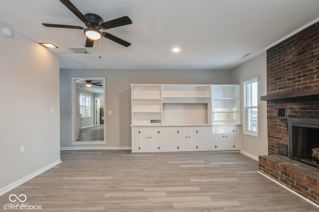 unfurnished living room with a fireplace, light hardwood / wood-style flooring, and a healthy amount of sunlight