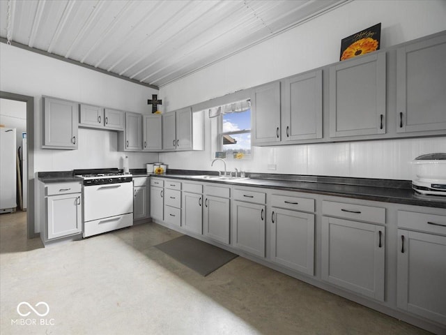 kitchen with white gas range, gray cabinets, sink, and refrigerator