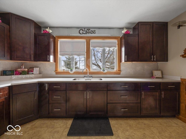kitchen with sink, backsplash, and dark brown cabinets