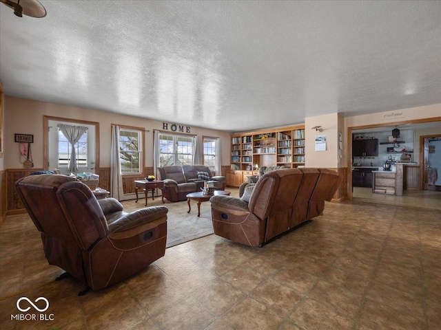 living room with wooden walls and a textured ceiling