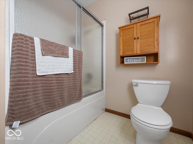 bathroom featuring bath / shower combo with glass door and toilet