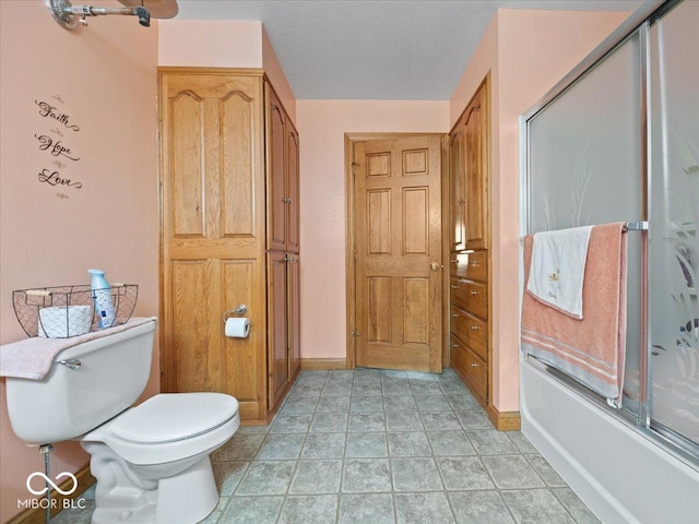 bathroom featuring enclosed tub / shower combo, tile patterned floors, toilet, and a textured ceiling
