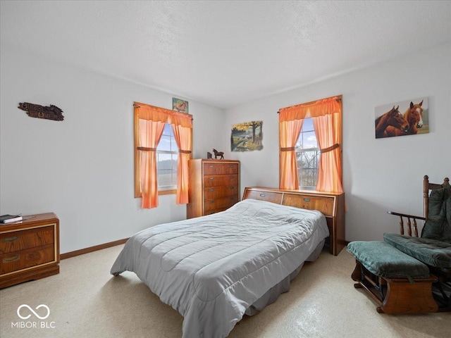 carpeted bedroom with multiple windows and a textured ceiling