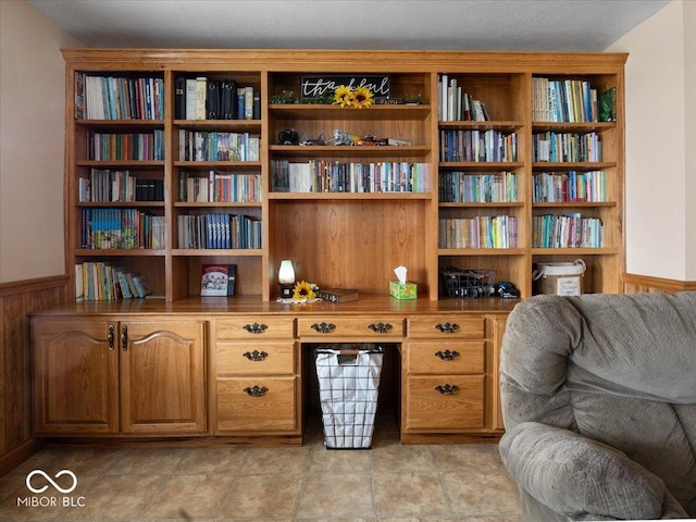 sitting room with built in desk and wooden walls