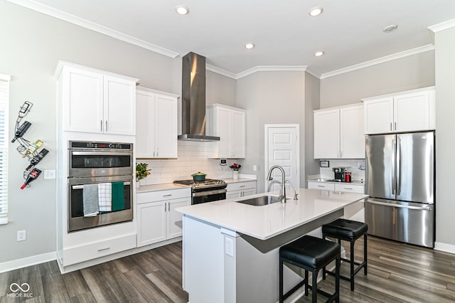 kitchen with stainless steel appliances, a sink, white cabinetry, light countertops, and wall chimney exhaust hood